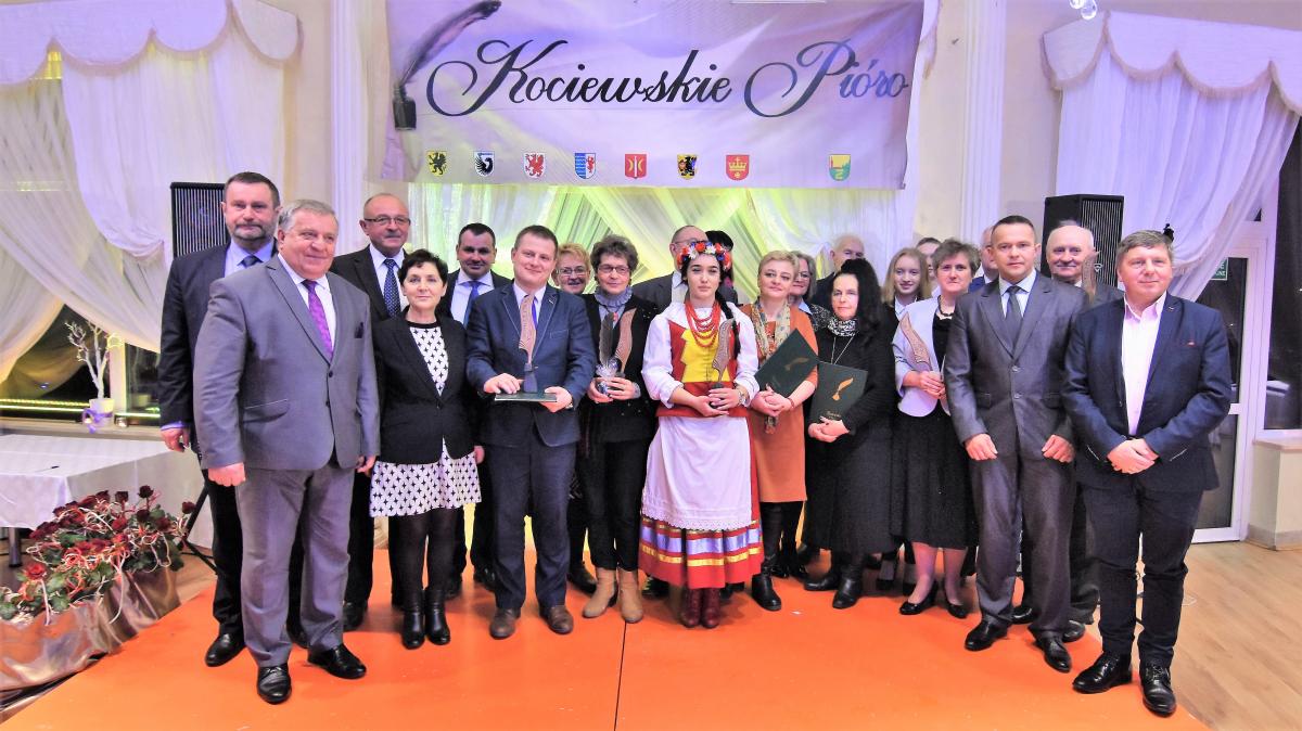 Grupa laureatów nagrody Kociewskie Pióro stoi wspólnie na tle baneru z nazwą konkursu