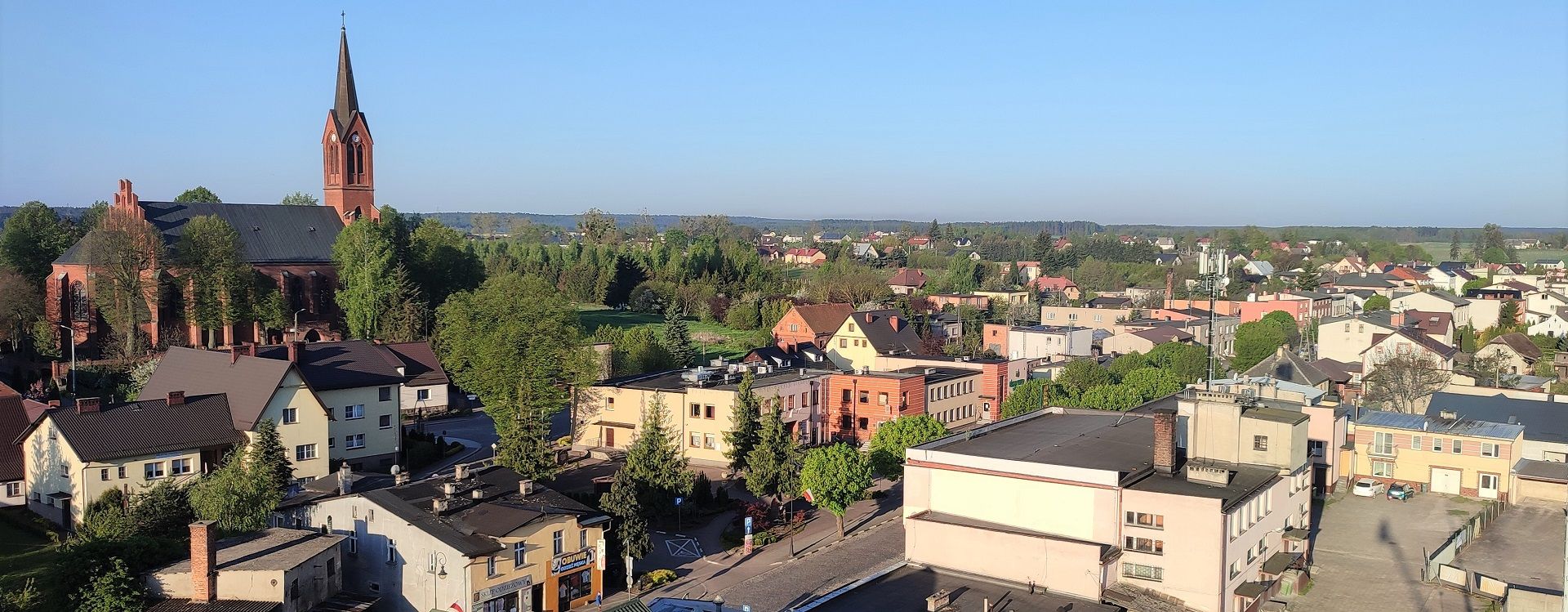 panorama centrum Zblewa z lotu ptaka widoczny ciąg domów, kościół i urząd gminy przy ul.Głównej