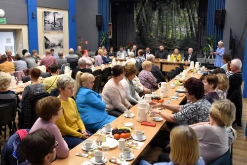 zdjęcie przedstawia salę ośrodka kultury wypełnioną siedzącymi ludźmi