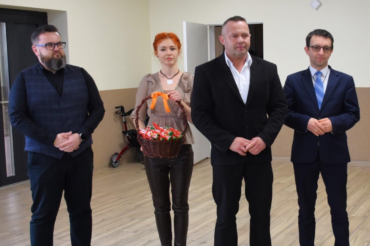 zdjęcie przedstawia galowo ubraną publiczność, przemawia wójt