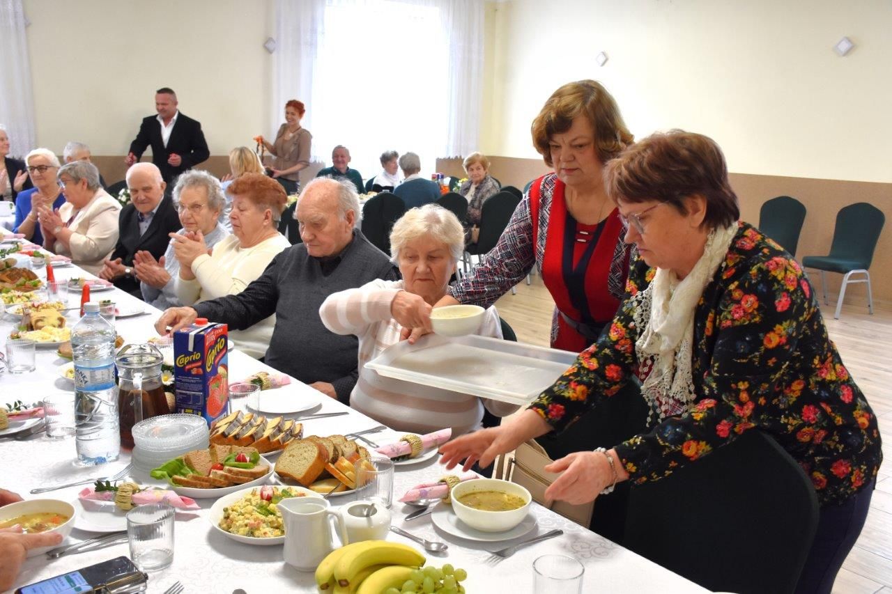 zdjęcie przedstawia ludzi siedzących na stole