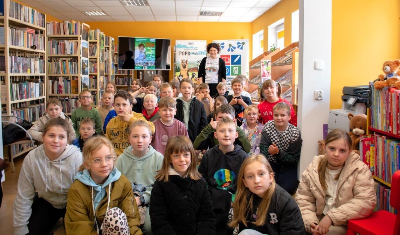 czytelnicy w bibliotece autor z książką