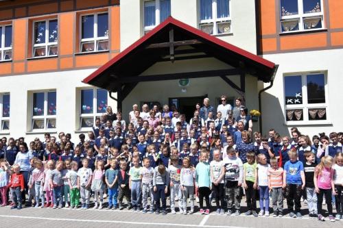 dzieci stojace na schodach przed szkołą