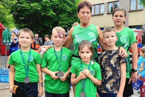 SPORTOWCY W ZIELONYCH KOSZULKACH PODCZAS BIEGU